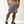 Load image into Gallery viewer, front side of Athletic Grey Shorts, with hand in pocket 
