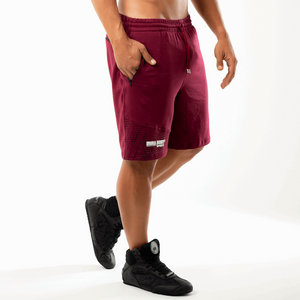side of Athletic Dark Red Shorts, with hand in pocket 